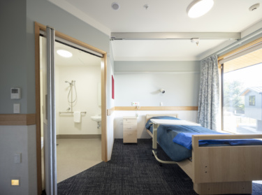 An interior shot of a room showing a bed and an ensuite with facilities for disabled persons